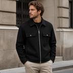 Man styling the black men's cargo jacket on a quiet US city street.