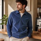 Man wearing the haze blue men's corduroy jacket in a softly lit US cafe.