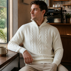 Man wearing the white men's half zip sweater in a softly lit US cafe.