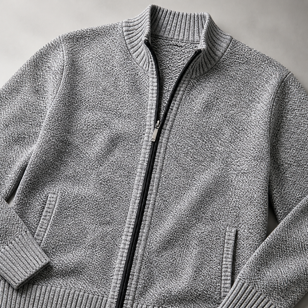 Close view of the light grey men's knit cardigan jacket showing its neckline and distinctive surface texture.