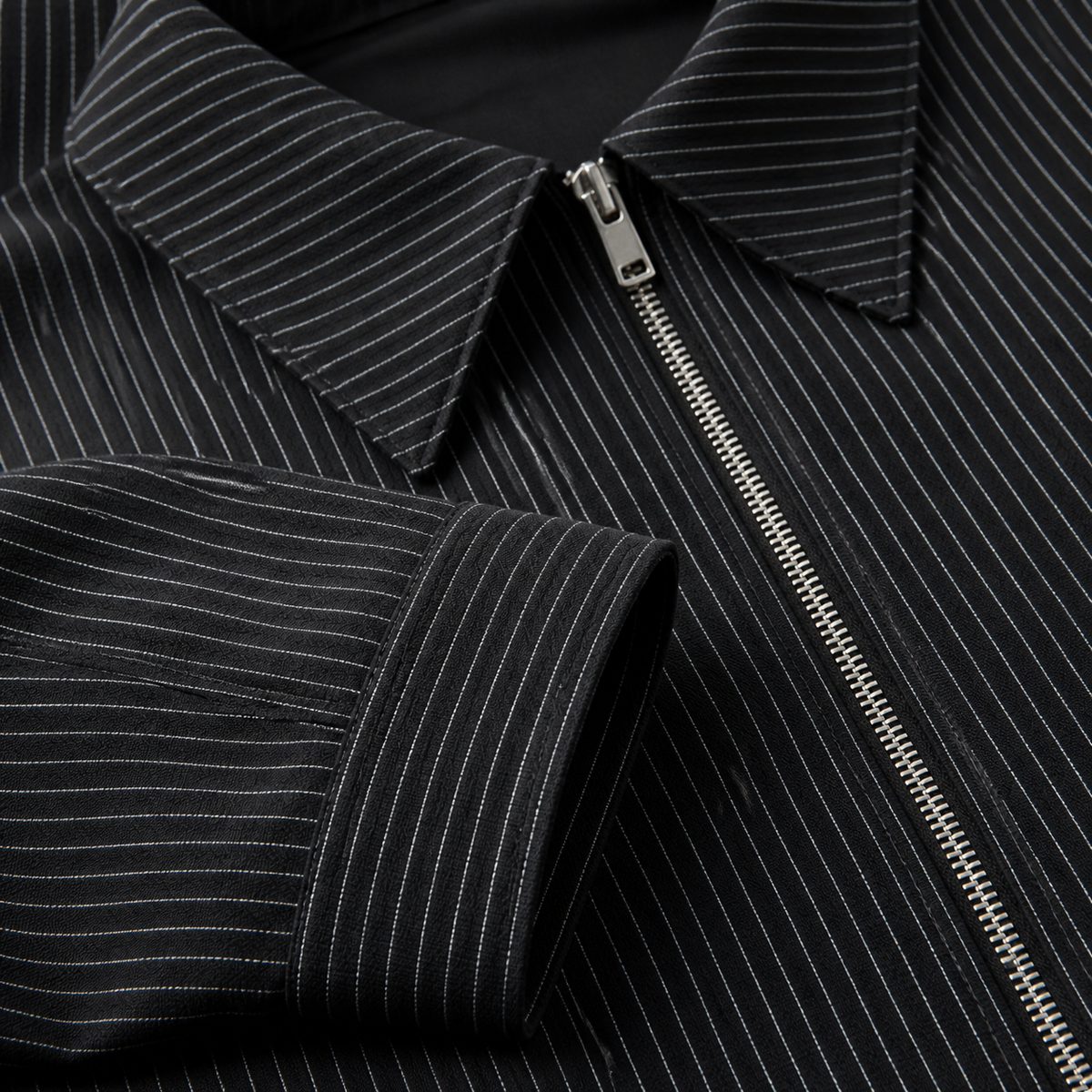 Close view of the black men's pinstripe jacket showing its neckline and distinctive surface texture.