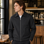 Man wearing the black men's pinstripe jacket in a softly lit US cafe.