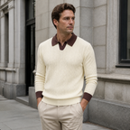 Man styling the apricot men's polo sweater on a quiet US city street.