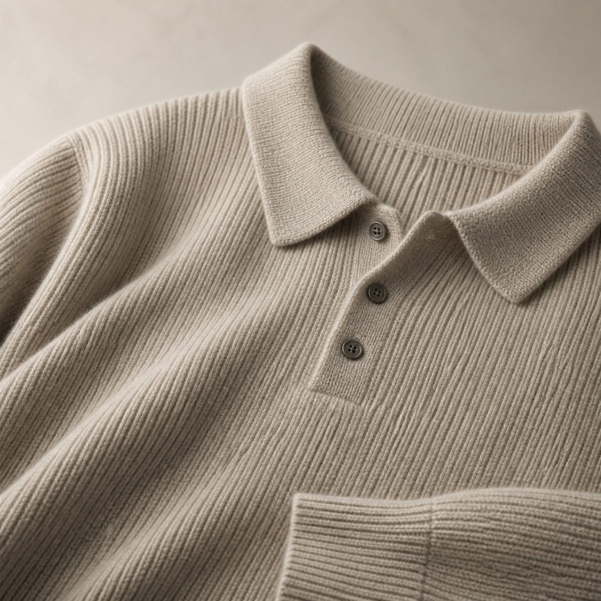 Close view of the oatmeal color men's polo sweater showing its neckline and distinctive surface texture.