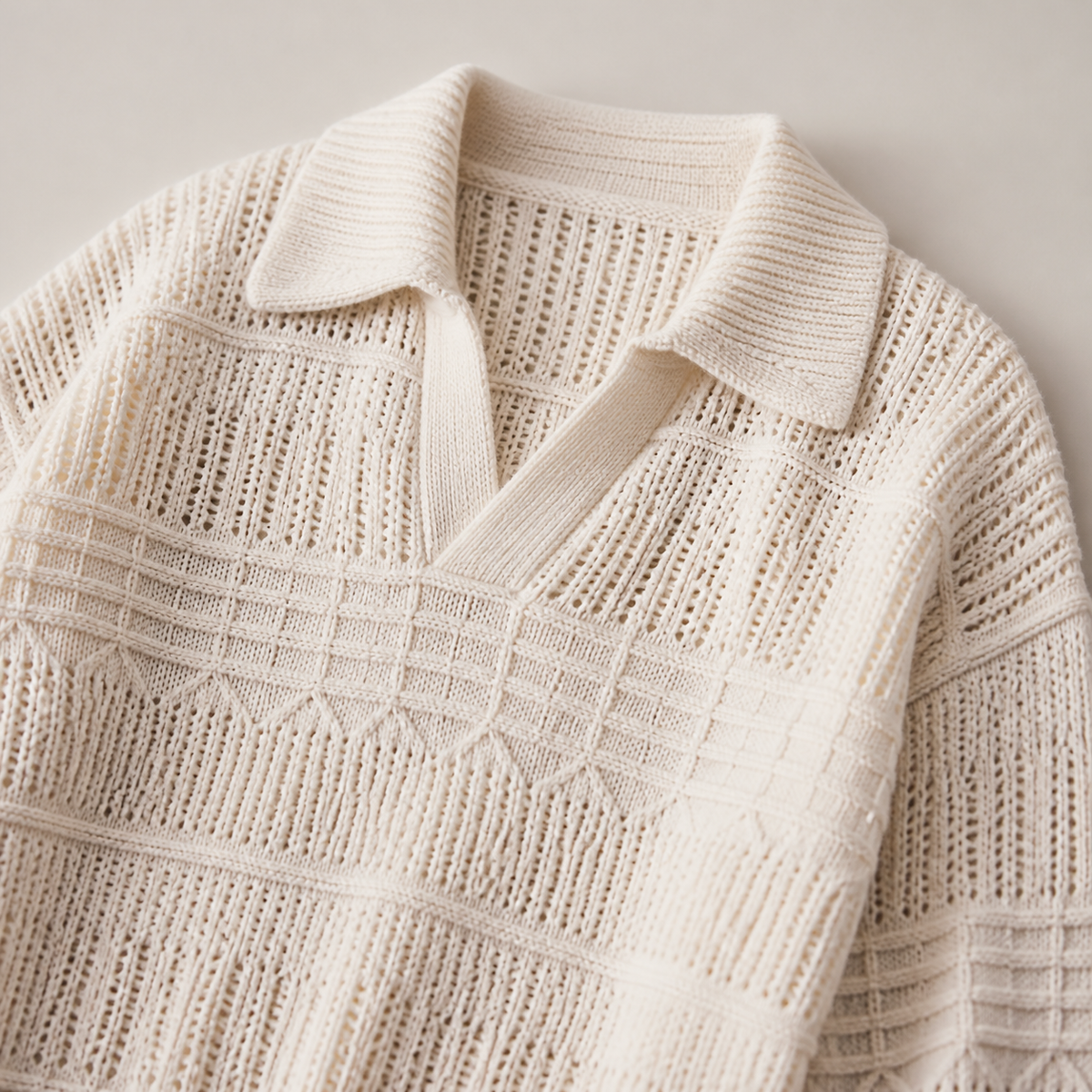 Close view of the apricot men's polo sweater showing its neckline and distinctive surface texture.