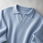 Close view of the light blue men's polo sweater showing its neckline and distinctive surface texture.
